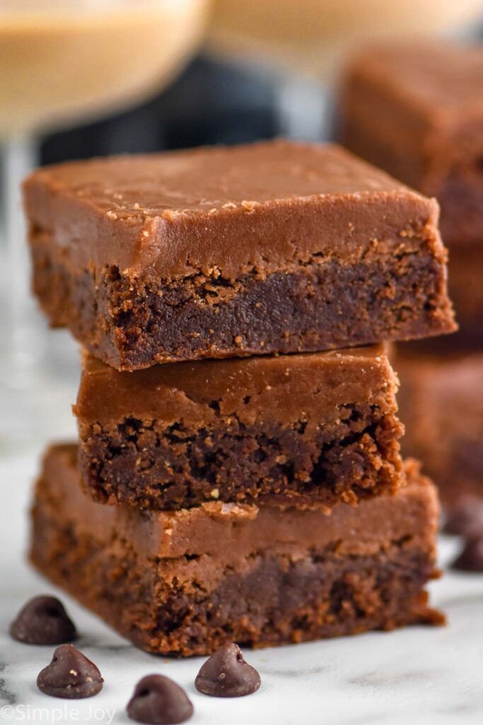 three pieces of chocolate brownie stacked on top of each other with one bite taken out