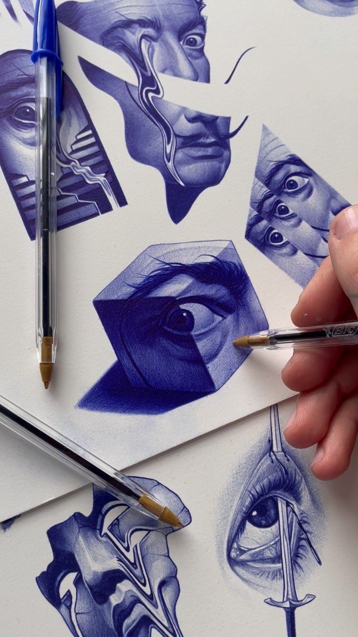 a person is holding a pen and drawing on paper with blue ink while another hand holds a pencil in front of them