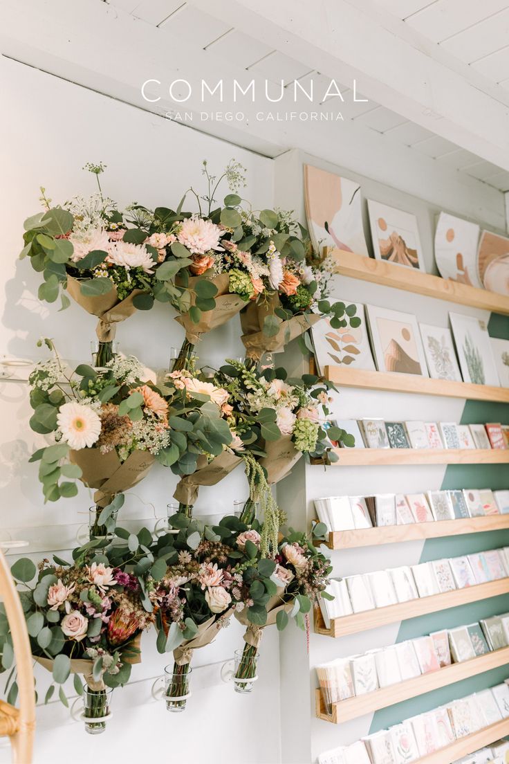 flowers and greenery are arranged on the wall