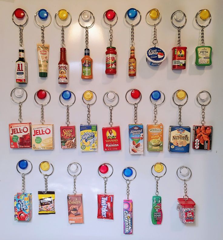 a bunch of food items are hanging on the wall with some key chains attached to them