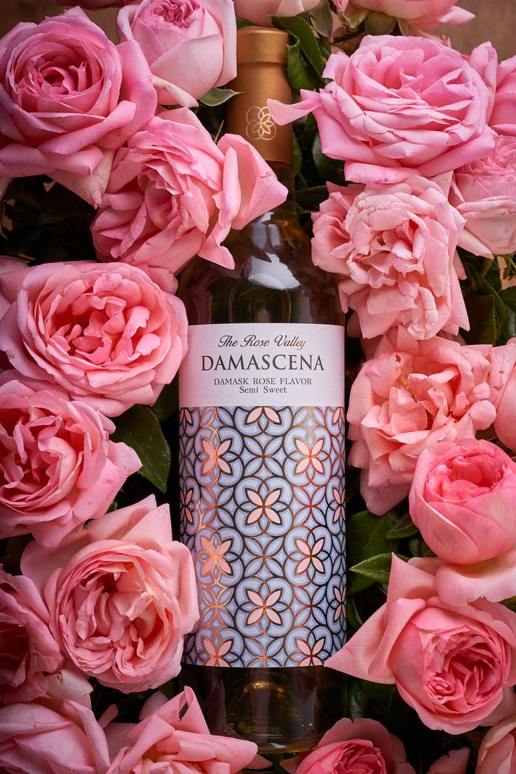 pink roses surround a bottle of damascena wine