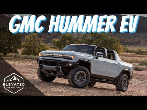 a silver truck parked on top of a dirt field next to trees and mountains with the words gmc hummer ev written above it