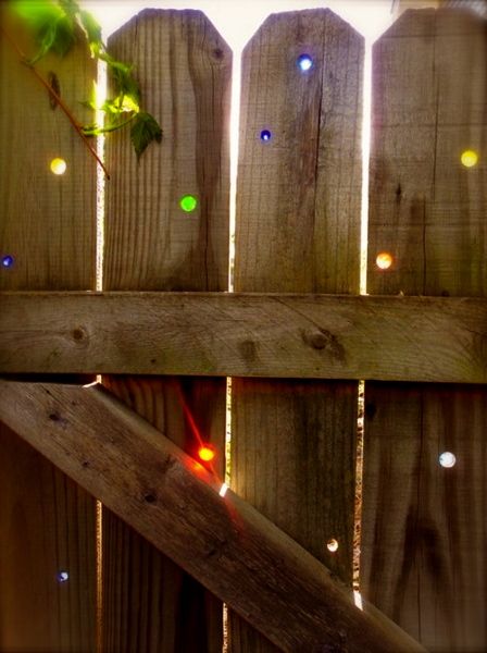 an iphone screenshot of a fence with the text kind of fascinating by this idea - drill holes in an exciting privacy fence and pop in glass marbles, when the sun streams through