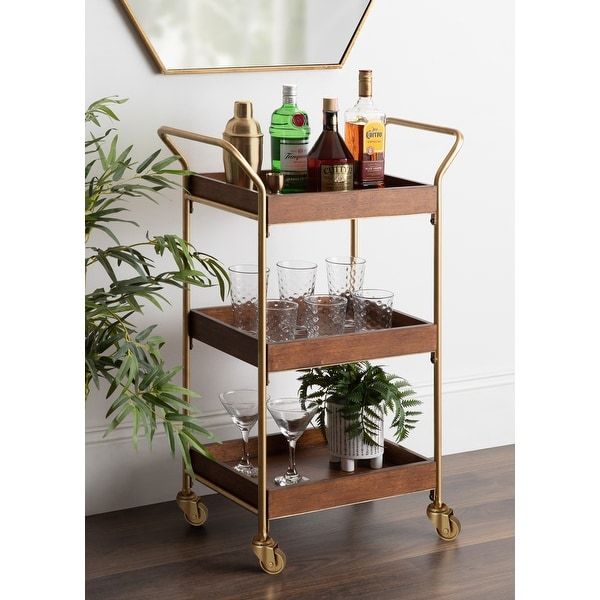 a gold bar cart with drinks on it