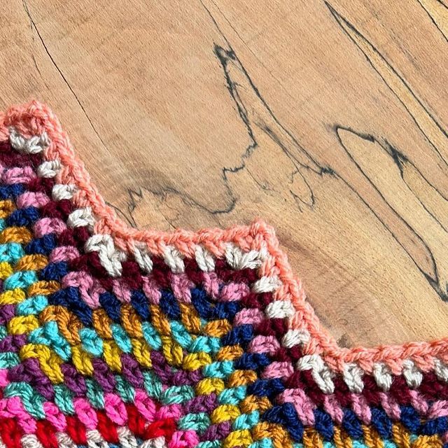 a crocheted piece of cloth sitting on top of a wooden table