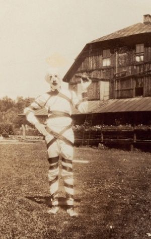 an old photo of a clown standing in the grass