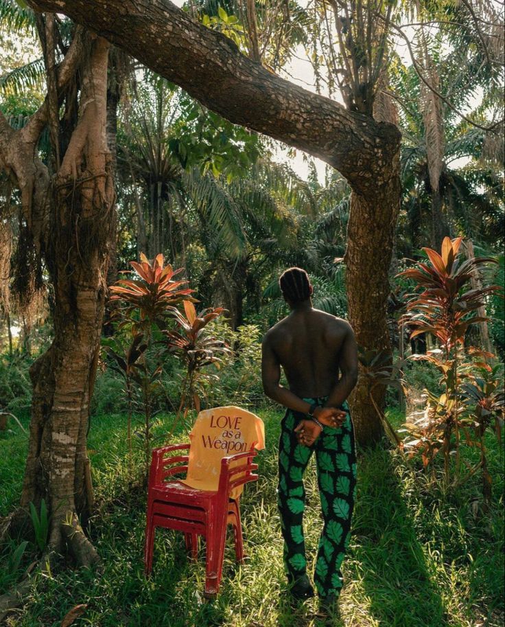 a man standing in the grass next to a chair