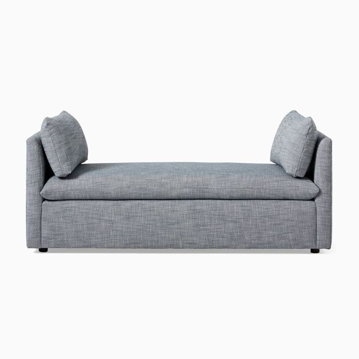 a gray couch with two pillows on it's back and the seat upholstered