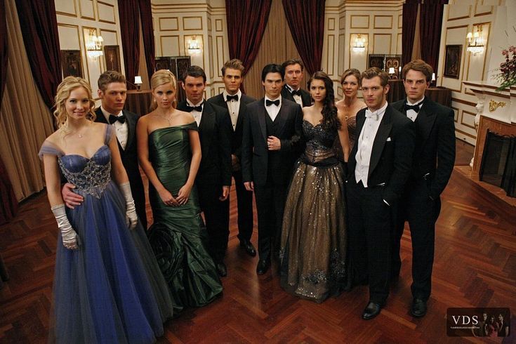 a group of people standing next to each other in formal wear