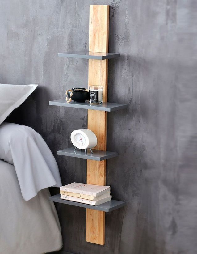 a bedroom with a bed, nightstand and book shelf in the corner on the wall