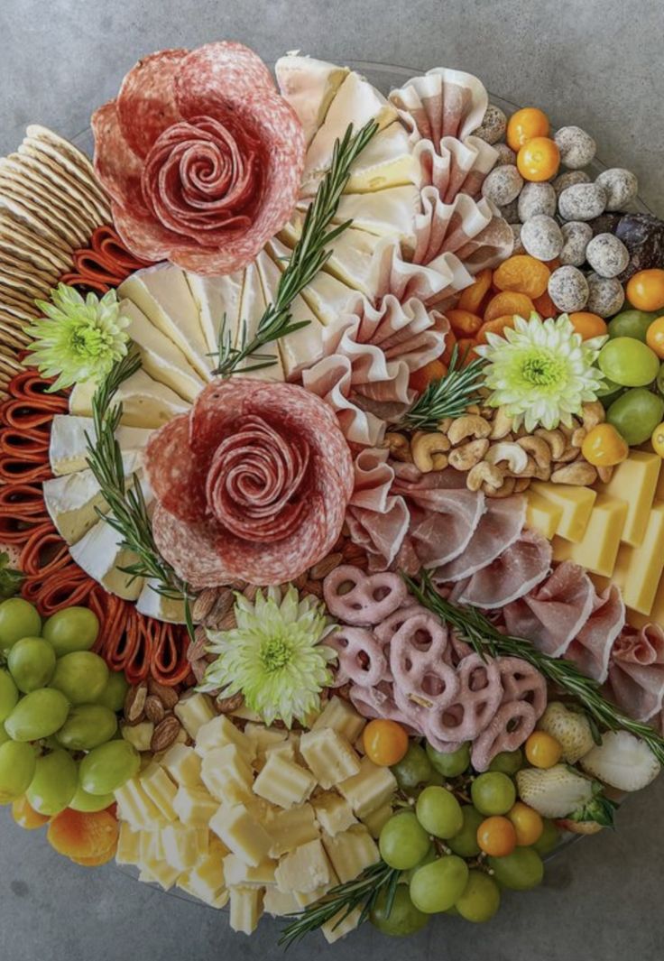 a platter filled with different types of cheeses, meats and vegetables on top of each other