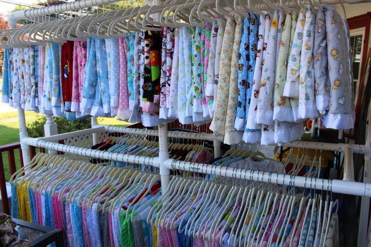 many different colored shirts are on display in a rack at an outdoor clothing store,