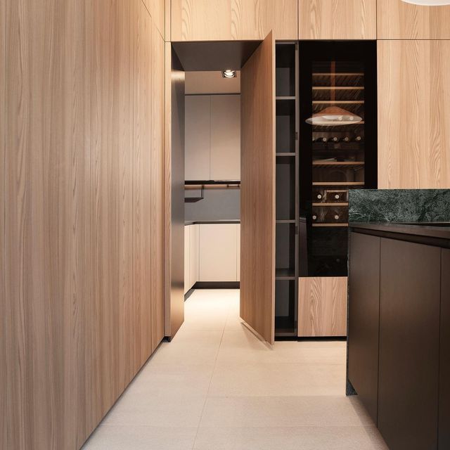 an empty kitchen with wooden cabinets and marble counter tops