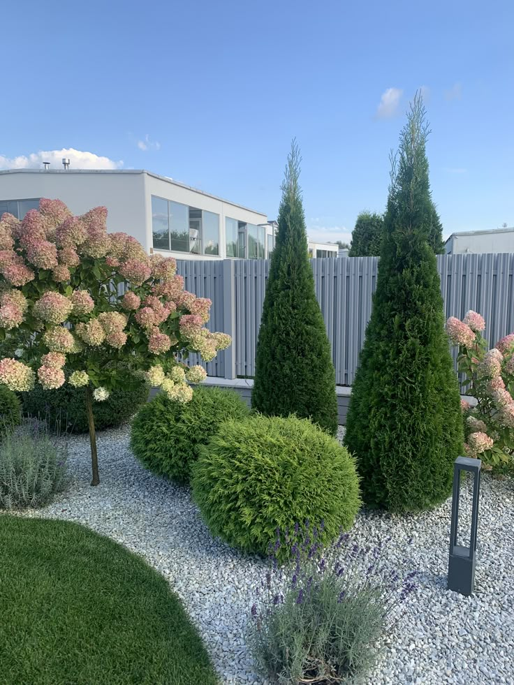 some bushes and trees in a graveled area