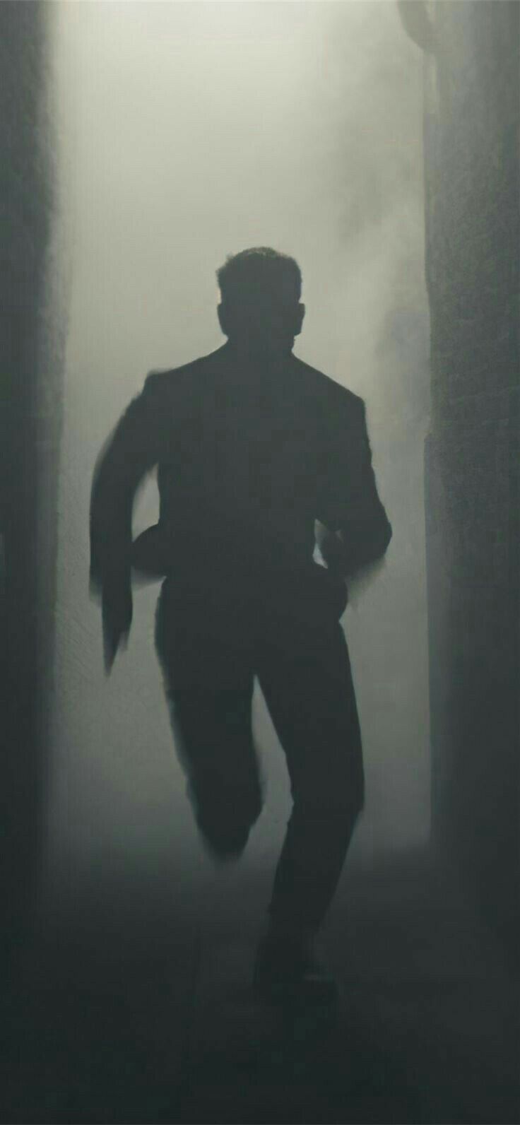 the silhouette of a man running through fog