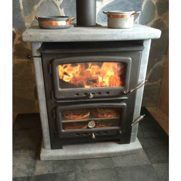 a stove that has some pots on top of it in front of a stone wall