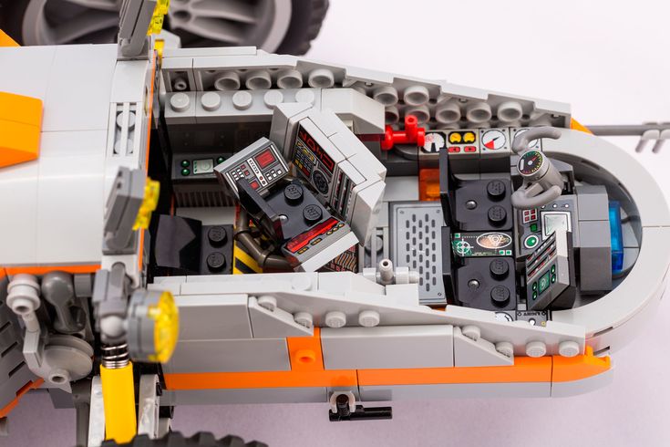 an orange and white lego car is shown from the top down, with other parts on it