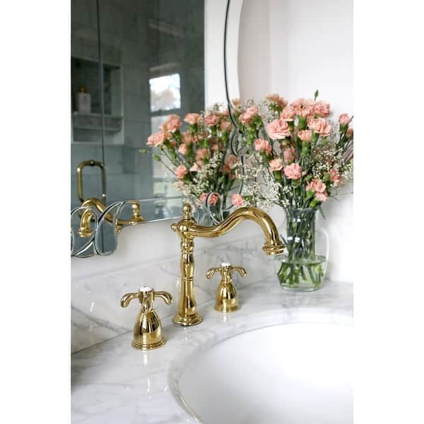 a bathroom sink with two faucets and flowers