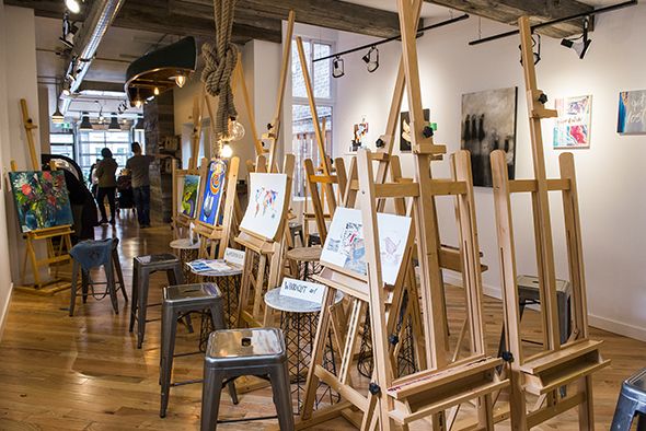 an art studio with easels and paintings on display