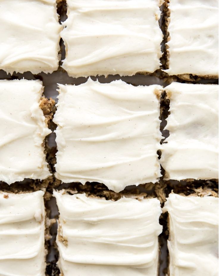 several squares of white frosted cake sitting on top of each other