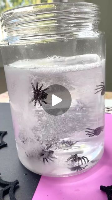 a glass jar filled with liquid and black bats