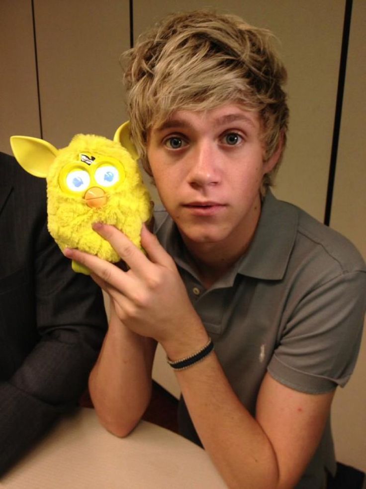 a young man holding up a yellow stuffed animal