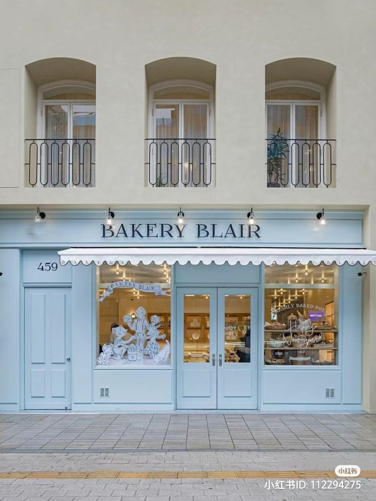 a bakery that is sitting on the side of a building in front of some windows