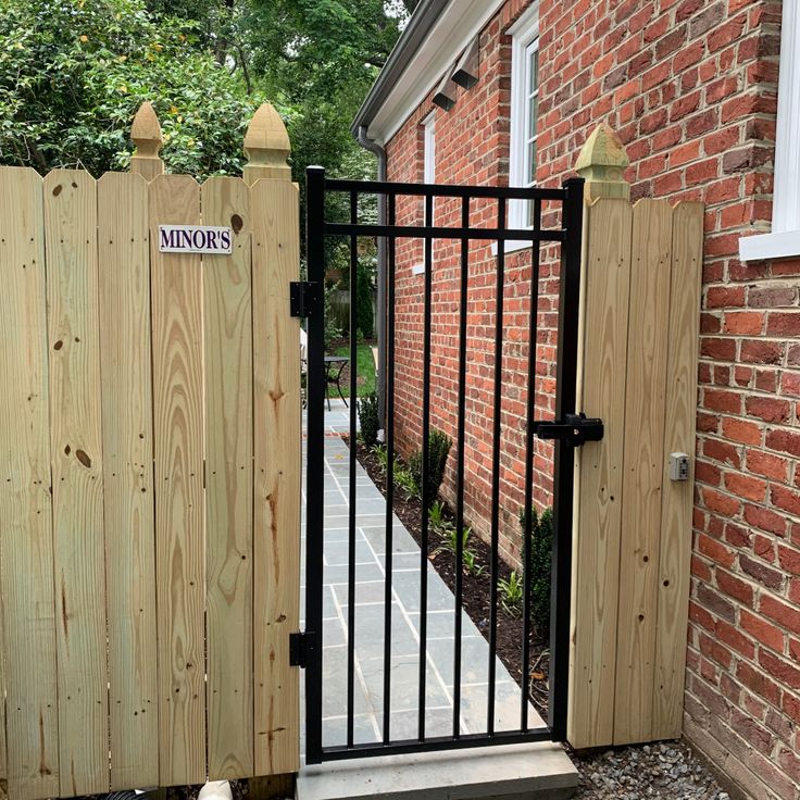 a gated entrance to a brick house with a sign on it that reads, windows