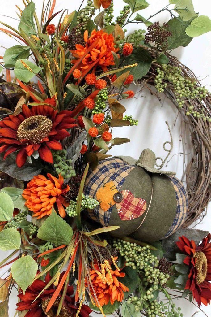 a fall wreath with pumpkins and flowers