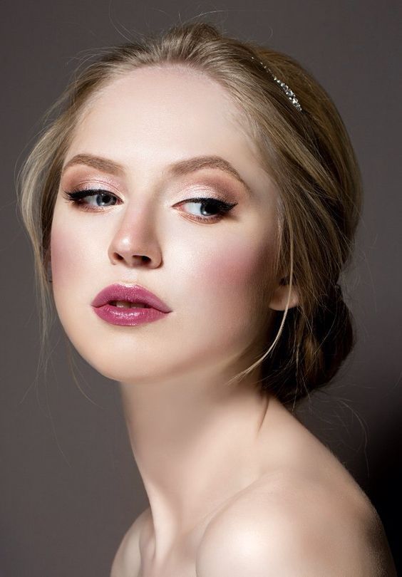 a woman with makeup on her face posing for the camera