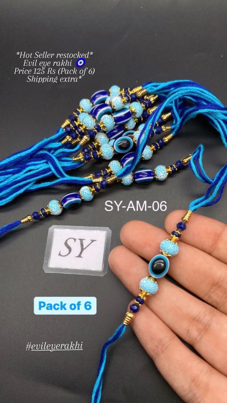 a hand is holding a blue beaded necklace