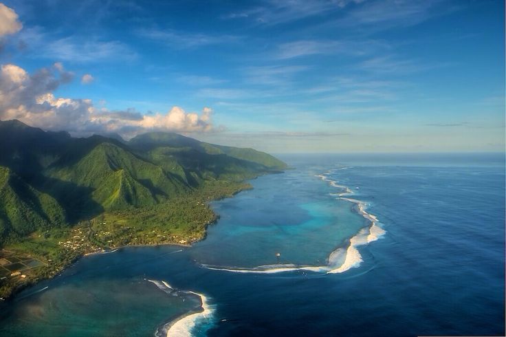 an aerial view of the ocean and landforms in the tropical island with blue water