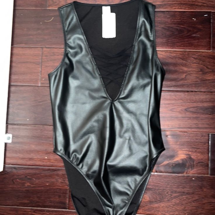 Black Leather Bodysuit. Never Worn. Size Medium Edgy Bodysuit For Spring Night Out, Edgy Bodysuit For Night Out In Spring, Edgy Sleeveless Bodysuit For Party, Edgy Sleeveless Party Bodysuit, Trendy Lined Bodysuit For Night Out, Trendy Bodysuit With Lined Body For Night Out, Sleek Black Bodysuit For Spring, Edgy Sleeveless Bodysuit For Night Out, Sleek Bodysuit For Night Out In Spring