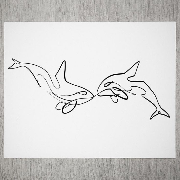 a drawing of two dolphins in black and white on a piece of paper with wood background