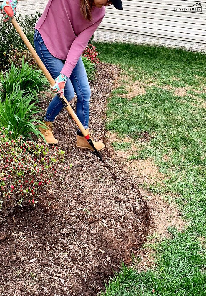 a woman is digging in the dirt with a shovel