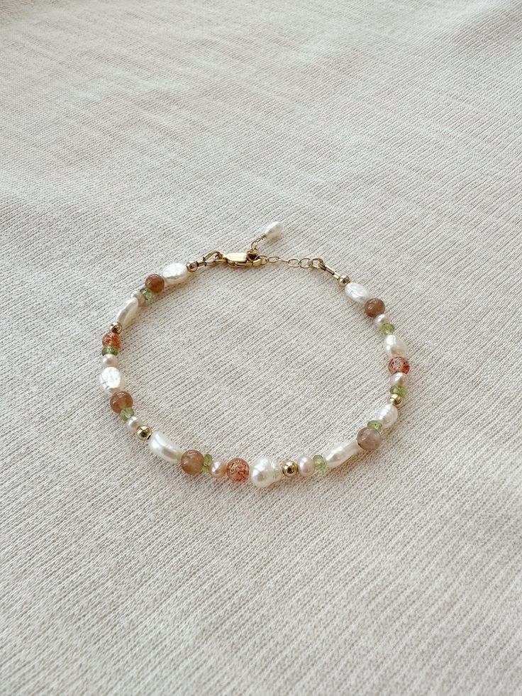 "Please review the bracelet sizing guide below for the perfect fit! This mixed gemstone and pearl beaded bracelet makes a lovely addition to your bracelet stack! The genuine moonstone, sunstone, peridot, and pink pearls are accented by creamy white pearls. Each bracelet is hand beaded to order 🫶🏻 * 2-9mm mixed natural Gemstones and Pearls * 14K Gold Filled or 925 Sterling Silver accents * 14/20 GF 925 stamp for authenticity * Made with all hypoallergenic materials 🤍 * Choose your length. Each bracelet comes with a 1\" extender chain for adjustable sizing. Bracelet Sizing Guide: 5-6.5 inches = xtra small 6.5-7 inches = small 7-8 inches = medium 8 inches+ = large Each Bracelet is measured held taught from tip to end. Unsure what size to choose? The best way to find the right size is to ta Dainty Beaded Bracelets, Diy Pearl Bracelet, Dainty Pearl Bracelet, Beaded Bracelet Stack, Small Bead Bracelet, Sunstone Bracelet, Pearl Beaded Bracelet, Multicolor Bracelet, Peridot Bracelet