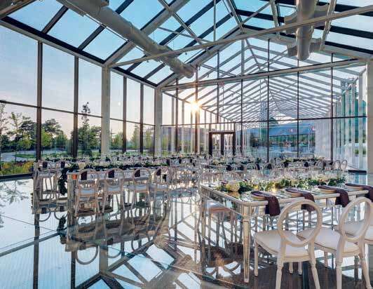 the inside of a building with tables and chairs set up for a formal dinner or function