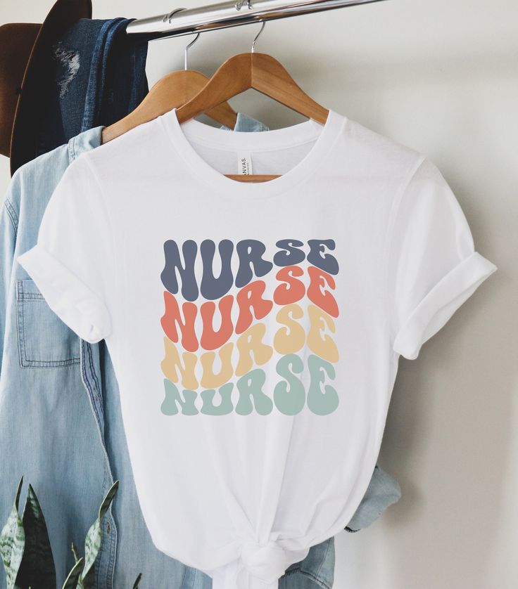 a white t - shirt with the words nurse on it hanging from a clothes rack