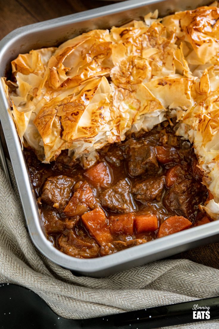 a casserole dish with meat, potatoes and gravy