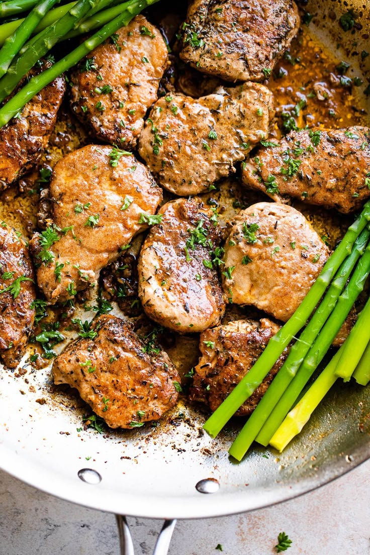 some meat and asparagus are in a pan