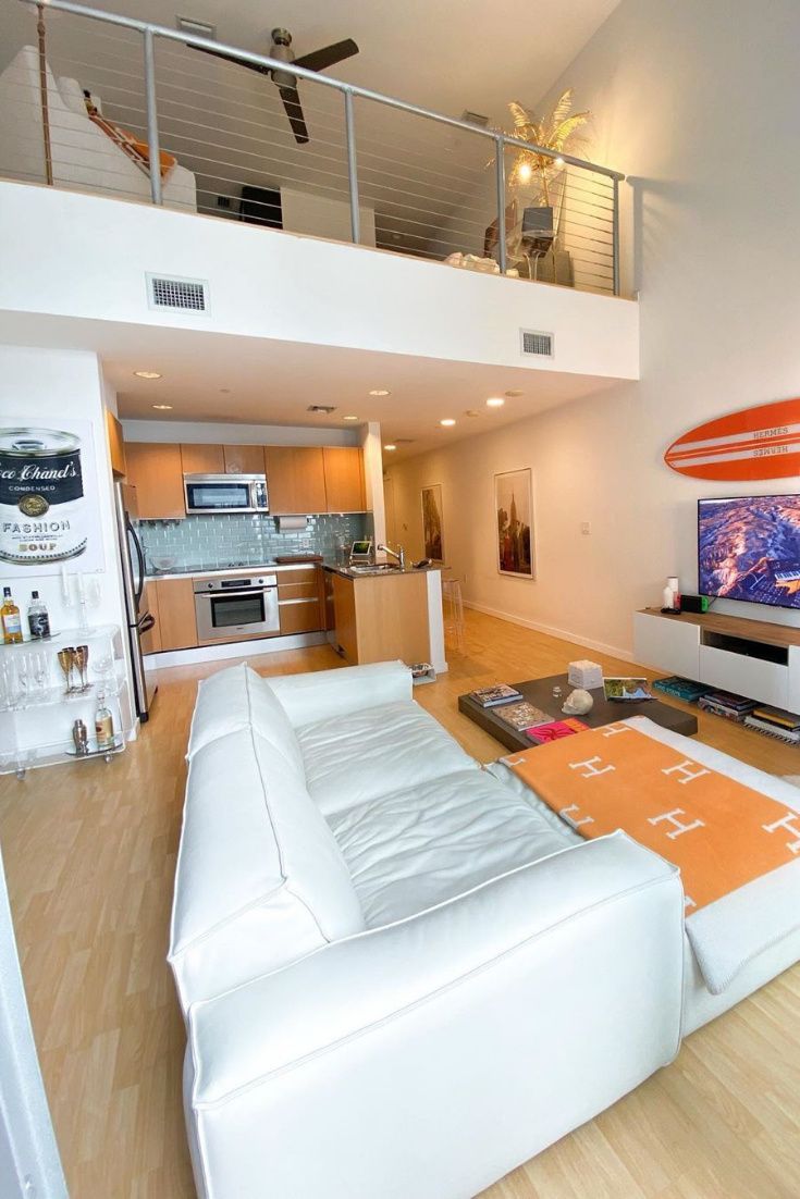 a living room filled with furniture and a large flat screen tv mounted to the wall