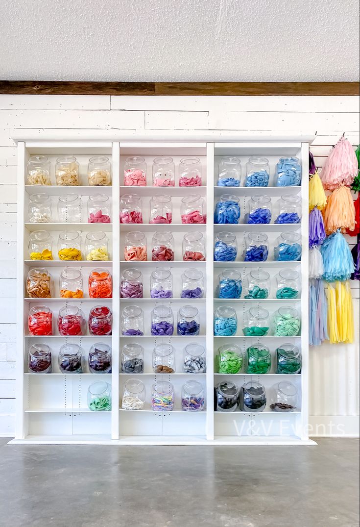 the shelves are filled with many different colored beads and other items in plastic bags on them