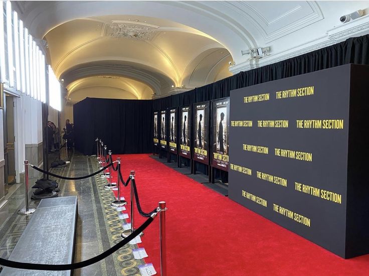 a red carpeted room with black walls and yellow lettering on the wall behind it