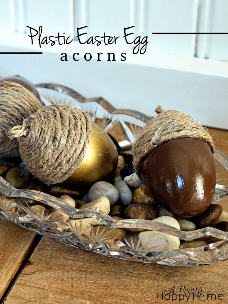 some acorns are sitting in a glass bowl on the ground with rope and twine