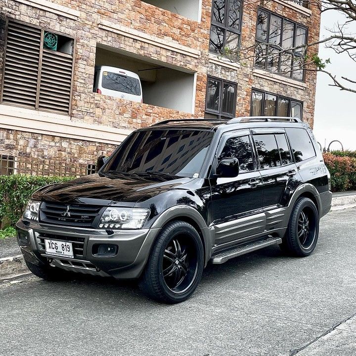 a black suv parked in front of a brick building