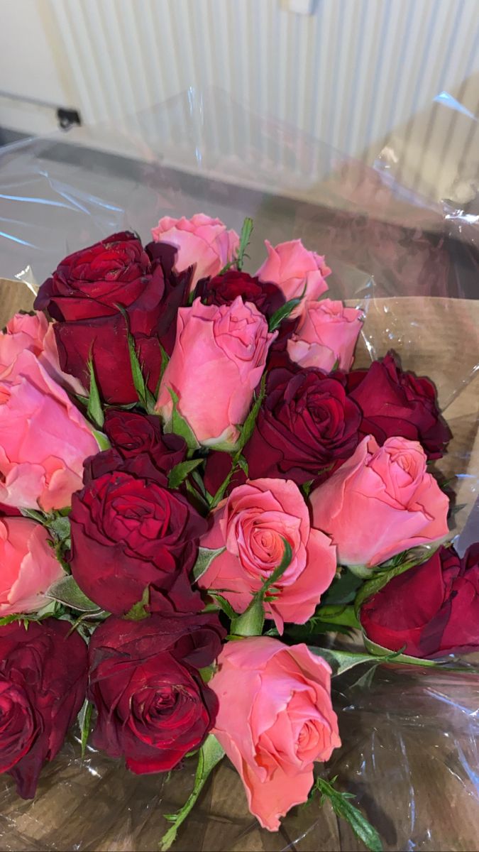 a bouquet of pink and red roses on a table