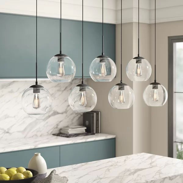 a kitchen with marble counter tops and hanging lights