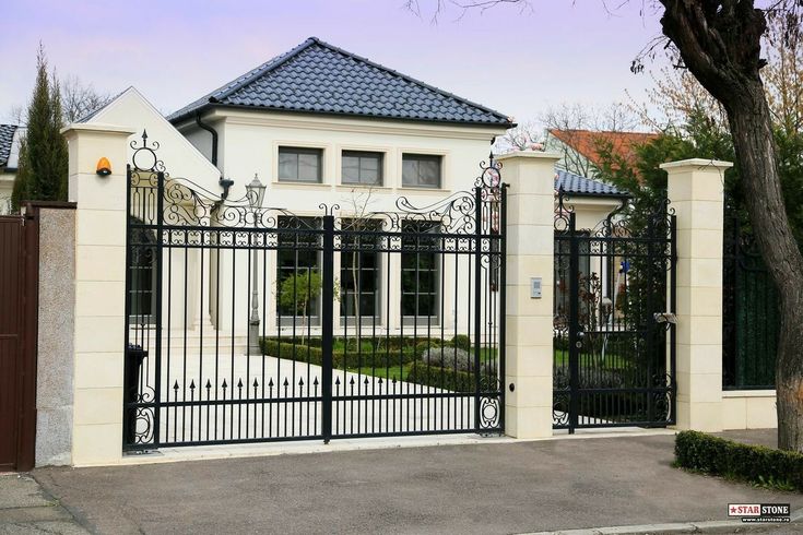 a large white house with a black gate