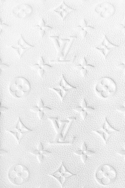 an up close view of the white leather textured fabric with monogrammed letters on it