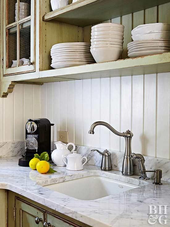 a kitchen counter with plates and bowls on it, next to a sink that has a faucet